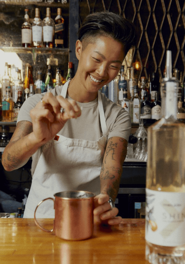 Kristen Kish crafting a cocktail behind the bar