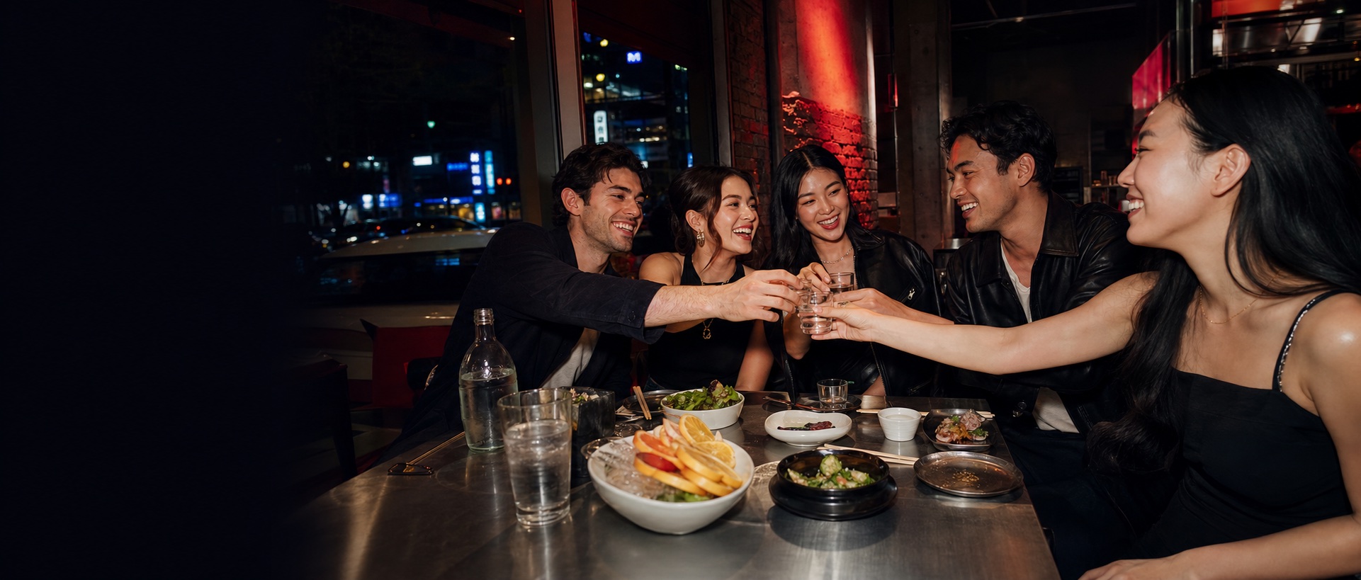 Friends sharing soju and Korean food during a night out in Koreatown