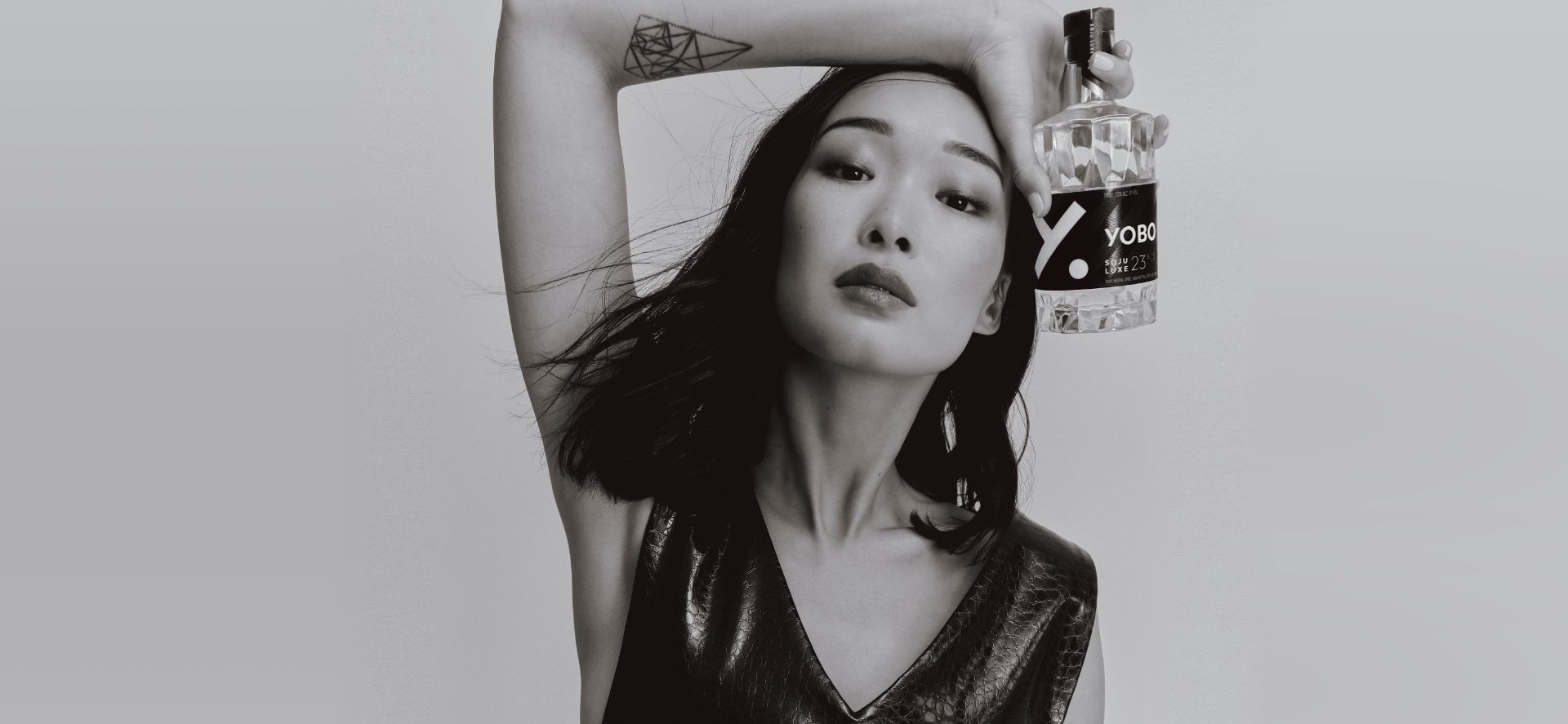 Model holding a bottle of YOBO Luxe soju